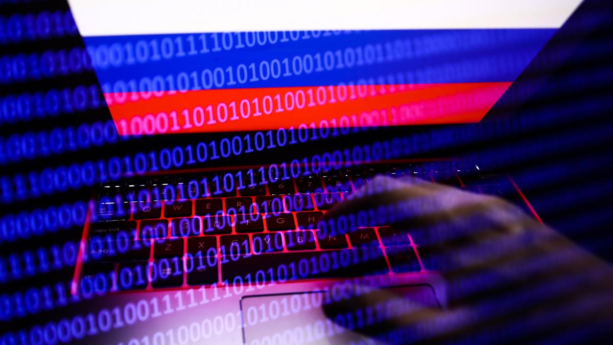 Russian flag displayed on a laptop screen and binary code code displayed on a screen are seen in this multiple exposure illustration photo taken in Krakow, Poland on February 16, 2022. (Photo illustration by Jakub Porzycki/NurPhoto via Getty Images)
