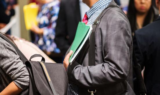 A job seeker holds a folder of documents during a job fair.