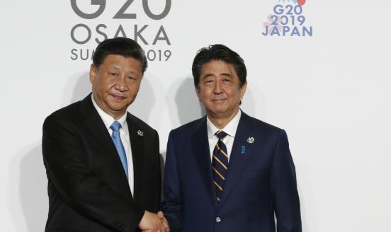 Chinese President Xi Jinping welcomed by Japanese Prime Minister Shinzo Abe for a family photo session on the first day of the G20 summit on June 28, 2019 in Osaka, Japan.