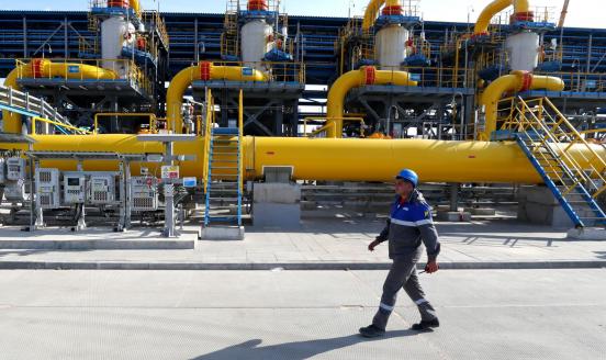 Worker walking in front of gas pipelines