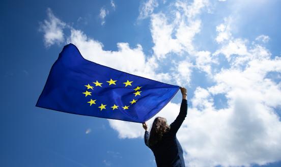 Woman holding the EU flag against the sky