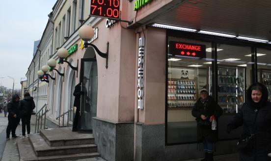  People walk past the exchange office showing the rates of the ruble against the US dollar on the facade, on January 23, 2023 in Moscow, Russia. 