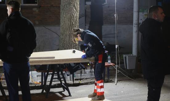 A volunteer from the Khaustov Charitable Foundation cuts chipboards to cover the windows in a residential building that are smashed by a Russian drone attack in Kharkiv, Ukraine, on April 4, 2025 (Photo by Viacheslav Madiievskyi/Ukrinform/NurPhoto via Getty Images)