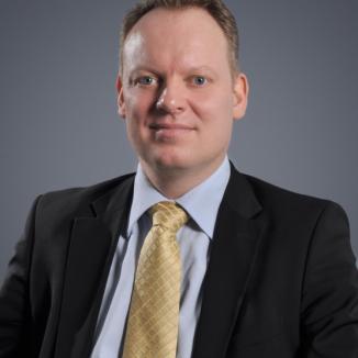 A man in a suite and a yellow tie