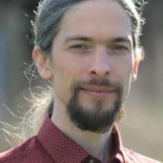 A man with long hair and beard, in a red shirt