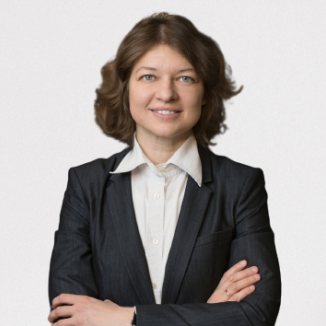 a woman with short brown hair in a classy suite, smiling brightly